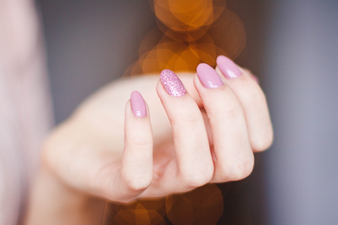 Finger nails of a woman painted pink